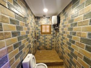 a bathroom with a toilet and a brick wall at Vim 2-BR-Apt With Fast Unlimited Internet & 24HRS Power in Lagos +37 photos