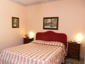 una camera con un letto e due comodini di HOTEL IL SILLABARIO a Iglesias