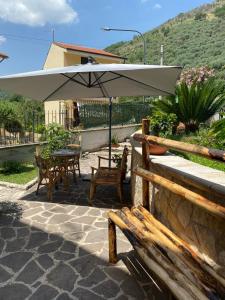 a table and chairs under an umbrella on a patio at Villa Angela in Lauro