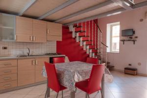 eine Küche mit einem Tisch mit roten Stühlen und einer Treppe in der Unterkunft Il molo Apartment 1 in Porto Empedocle