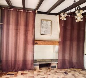 a room with purple curtains and a chandelier at Maison de campagne - La Belle Claudine in Laruscade