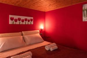 ein rotes Schlafzimmer mit einem Bett mit roten Wänden in der Unterkunft Il molo Apartment 1 in Porto Empedocle