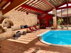 une terrasse avec une piscine et une maison dans l'établissement Maison de campagne - La Belle Claudine, à Laruscade