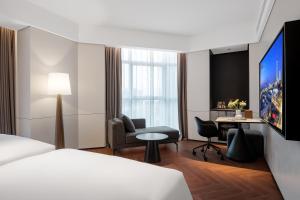 a hotel room with a bed and a desk at Intercity Wuhan Guanshan Avenue in Wuhan