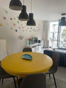 吉爾斯的住宿－Retiro das Andorinhas - Gerês，客厅里一张黄色的桌子和椅子