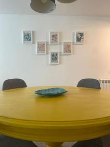 吉爾斯的住宿－Retiro das Andorinhas - Gerês，一张黄色桌子,上面有两把椅子和一个盘子