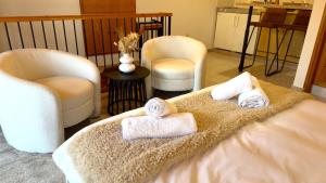 Habitación con 2 toallas en una cama con 2 sillas en Maison Damianou Elegant Loft, en Omodos
