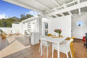 a patio with a white table and chairs at Marbella Real - 2 Bedroom Apartment in Marbella
