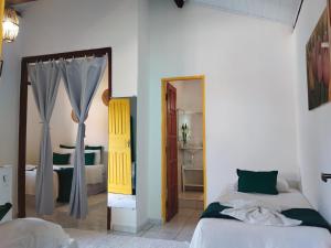 a bedroom with two beds and a mirror at Pousada João Maria in Trancoso