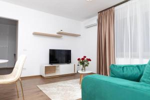 a living room with a blue couch and a tv at Enescu 3 City Center Flat in Timişoara
