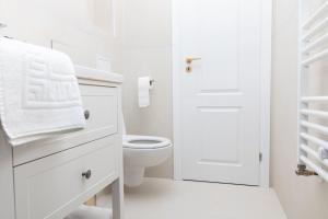 a white bathroom with a toilet and a white door at Enescu 3 City Center Flat in Timişoara