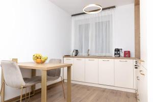 una cocina con armarios blancos y una mesa con bananas. en Enescu 3 City Center Flat, en Timisoara
