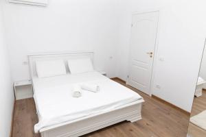 um quarto com uma cama branca com lençóis brancos em Enescu 3 City Center Flat em Timisoara