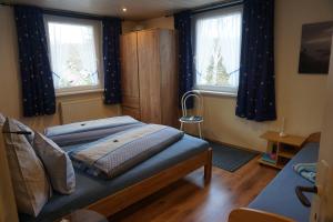 a bedroom with two beds and two windows at Ferienwohnung Familie Frank in Kurort Rathen