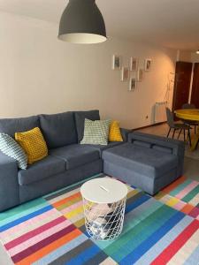 uma sala de estar com um sofá azul e um tapete colorido em Retiro das Andorinhas - Gerês no Gerês