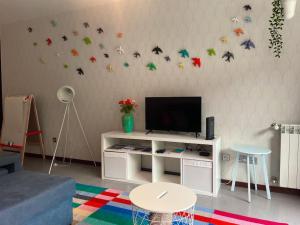 a living room with a tv with butterflies on the wall at Retiro das Andorinhas - Gerês in Geres