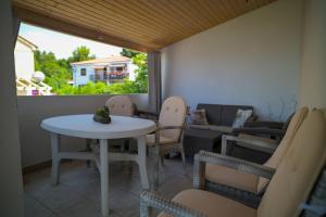 a room with a table and chairs and a window at Apartmani Helena in Mali Lošinj