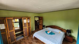 a bedroom with a bed and green walls at Lianita's Cottage (Selfcatering) in La Digue