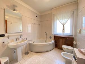 een badkamer met een bad, een wastafel en een toilet bij [Incantevole] - 15 Minuti da Duomo + Wifi, Parking in San Donato Milanese