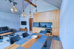 a living room with a wooden table and blue chairs at Mana Lake in Sieraków