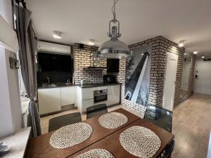 a kitchen with a wooden table and a dining room at Apartament Portowy in Hel