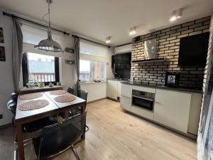 a kitchen with a table and a counter top at Apartament Portowy in Hel