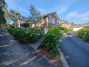 a brick house with plants in front of a driveway at Gorgeous 4-Bedroom House on a Mansion - an acre land with Magnificent Pool & Garden in Lower Plenty