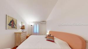 a white bedroom with a bed and a dresser at Appartamento Dream - Cala Granu in Porto Cervo