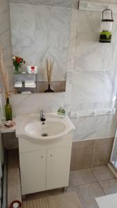 a white bathroom with a sink and a shower at Wild Glamping Portugal with hot tub to relax in Viana do Castelo in Viana do Castelo