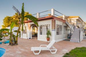 a house with a pool and a white chair at Casa Principal in La Rinconada