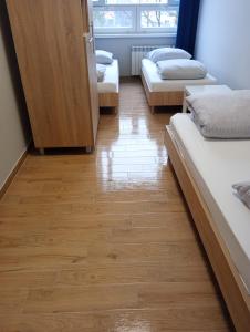 a room with three beds and a wooden floor at StarBal in Radom