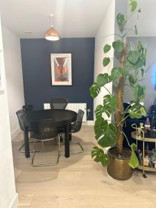 ein Esszimmer mit einem schwarzen Tisch und einer Pflanze in der Unterkunft West London Hideaway Suite in Ealing