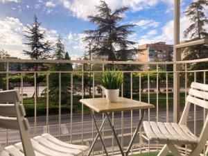 ein Balkon mit zwei Stühlen und einem Tisch auf einem Balkon in der Unterkunft Luninoso y práctico apartamento en el centro con amplio parking incluido in Granada