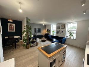 ein Wohnzimmer mit einer Küche und ein Wohnzimmer mit einem Sofa in der Unterkunft West London Hideaway Suite in Ealing