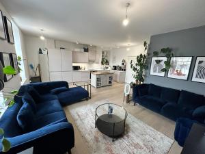 ein Wohnzimmer mit blauen Sofas und eine Küche in der Unterkunft West London Hideaway Suite in Ealing