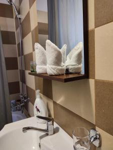 ein Badezimmer mit Waschbecken, Spiegel und Handtüchern in der Unterkunft Marian House in Sibiu