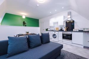 ein Wohnzimmer mit einem Sofa und einer Küche in der Unterkunft Charming abode near city centre/free parking in Liverpool