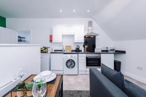 a kitchen with white appliances and a table with a couch at Charming abode near city centre/free parking in Liverpool