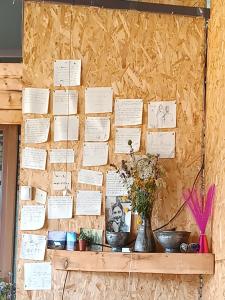 a bulletin board with white papers on a wall at Nadiani Hostel in Omalo