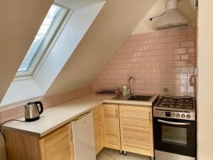 a kitchen with a sink stove and a window at Apartament W Dolinie Modrzewi in Kamienna Góra +18 photos