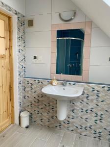 a bathroom with a sink and a mirror at Apartament W Dolinie Modrzewi in Kamienna Góra