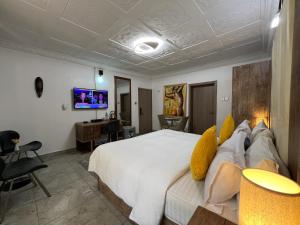 UrbaN RootZ في أبوجا: غرفة نوم مع سرير أبيض كبير ومكتب