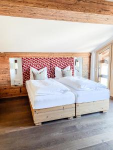 two twin beds in a room with wooden walls at B&B at Kreativhaus Tirol in Weerberg