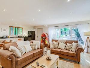 a living room with two brown couches and a kitchen at 1 Bed in Nidderdale 93258 in Darley