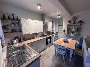 a kitchen with a sink and a table in it at Prince St Cottage - Haworth - Sleeps 4 in Haworth