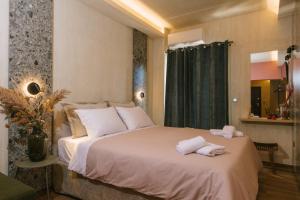 1 dormitorio con 1 cama grande y toallas. en Central Charm, en Kalamata