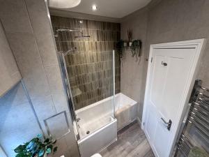 a bathroom with a shower and a tub and a toilet at Prince St Cottage - Haworth - Sleeps 4 in Haworth +13 photos