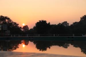 einen Sonnenuntergang über einer Brücke über einen Wasserkörper in der Unterkunft Green Valley Seas and Resorts in Ranchi
