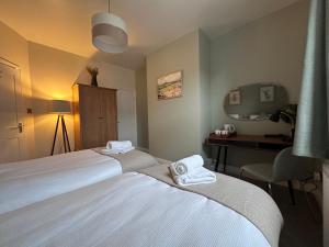 a hotel room with two beds and a desk at Prince Street Cottage - Haworth - Sleeps 4 in Haworth