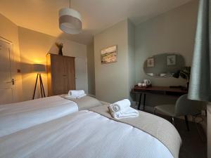 a hotel room with two beds and a desk at Prince St Cottage - Haworth - Sleeps 4 in Haworth